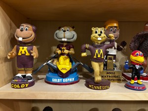 Many forms of Goldy Gopher and one form of Big Jay as Bobbleheads.